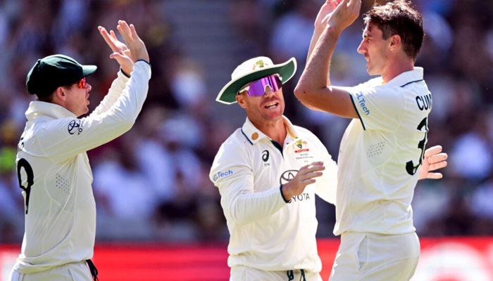 Australias Pat Cummins (R) celebrates with teammates Steve Smith (L) and David Warner (C) after dismissing Pakistans batsman Barbar Azam. — AFP