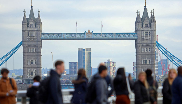 People walk over London Bridge looking at a view of Tower Bridge in the City of London financial district in London, Britain, October 25, 2023. — Reuters