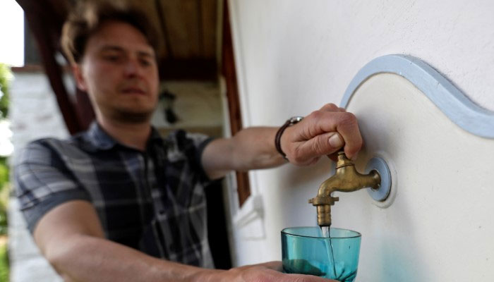 Milan Starec pours a glass of water from a tap at his home in the village of Uhelna near the town of Hradek nad Nisou, Czech Republic, June 15, 2021. — Reuters