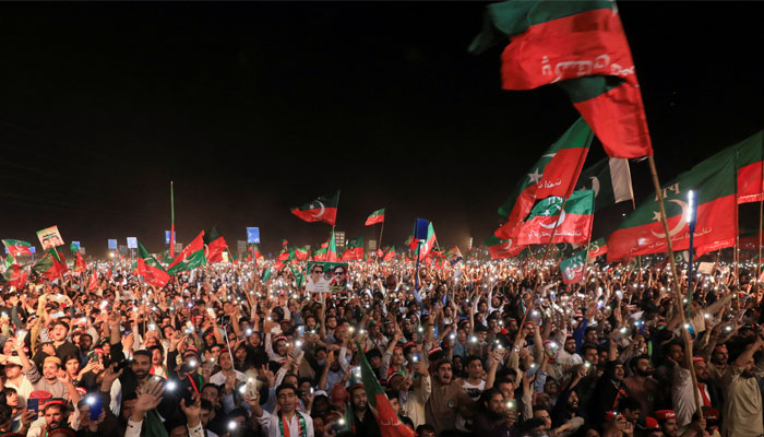 PTI supporters hoist their party flags in this undated picture. — Reuters/File