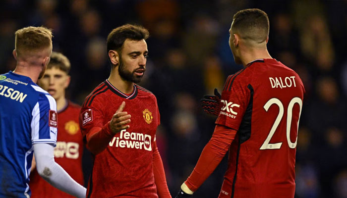 Manchester Uniteds Bruno Fernandes celebrates with Diogo Dalot after scoring their second goal from the penalty spot during the FA Cup third round match against Wigan Athletic at the DW Stadium in Wigan on January 8, 2024. — AFP