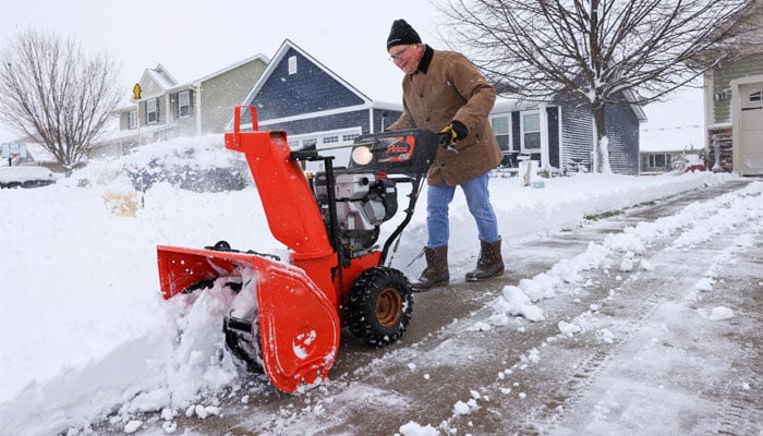 Daniel Henderson clears snow from his driveway after a winter storm passed through in Waukee, Iowa, U.S., on January 9, 2024. – Reuters