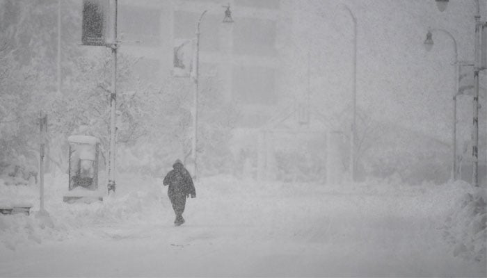 A person walks across the empty street during the first winter storm of 2024 which is expected to bring heavy snowfall across the northeast United States, in Worcester, Massachusetts, US, on January 7, 2024. — Reuters