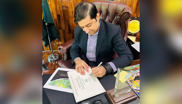 Caretaker minister Arshad Wali Muhammad signs on the certificate presented to Aneeqa. — Supplied