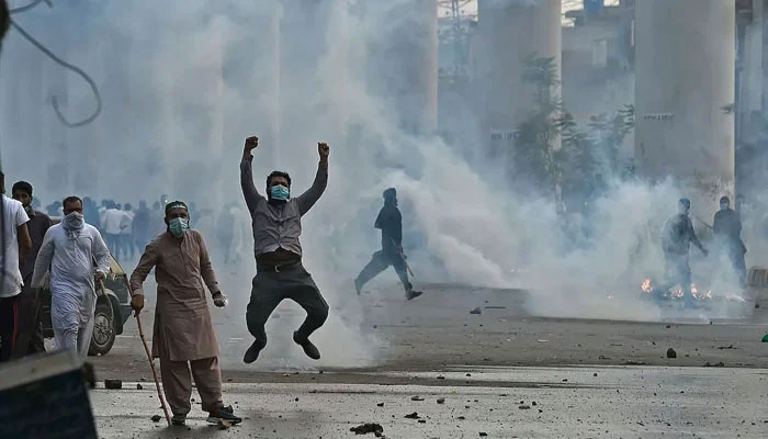 Police use tear gas to disperse supporters of the Tehreek-e-Labbaik Pakistan (TLP), during a protest in Lahore on April 12, 2021, after the arrest of their leader. — AFP
