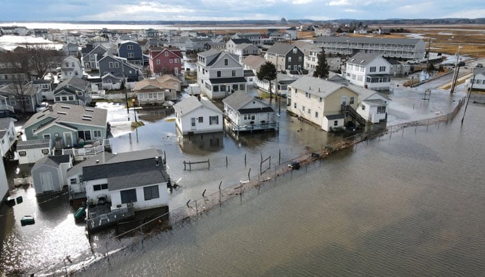 This aerial view shows homes are surrounded by flood waters in Hampton, New Hampshire, on January 10, 2024. — AFP