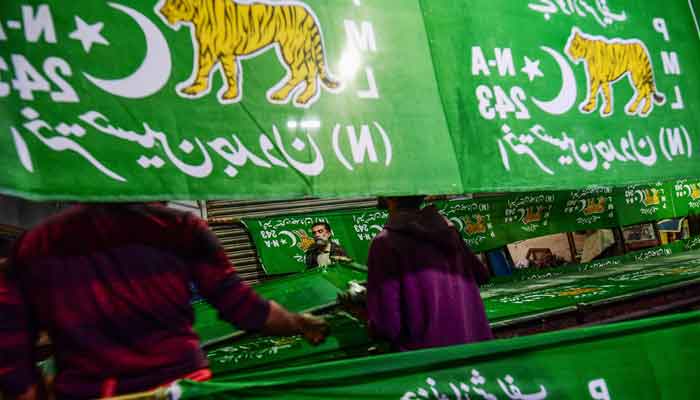 Workers use the screen printing technique to make banners of the PML-N with the party symbol at a workshop in Karachi on January 10, 2024, ahead of upcoming general election. —AFP