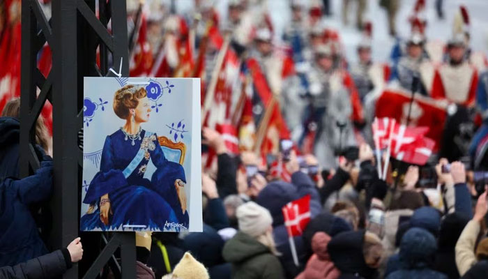 A sign depicting Queen Margaret of Denmark is displayed as royal guards pass by on the day Queen Margaret abdicates after 52 years on the throne, and her eldest son, Crown Prince Frederick, ascends the throne as King Frederick X , in Copenhagen, Denmark, in January.  September 14, 2024.—Reuters