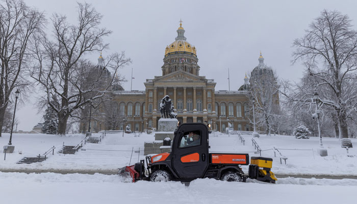 Workers remove snow from the sidewalk outside of the Iowa State Capitol Building after a snowstorm left several inches of snow in Des Moines, Iowa, US, January 9, 2024. —Reuters