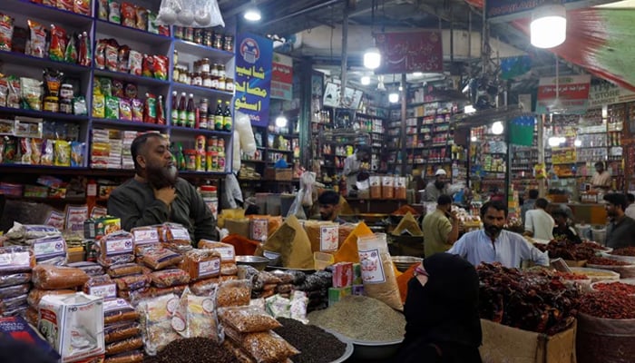 A customer speaks with a shopkeeper selling grocery items at a market in Karachi, Pakistan June 8, 2023. — Reuters