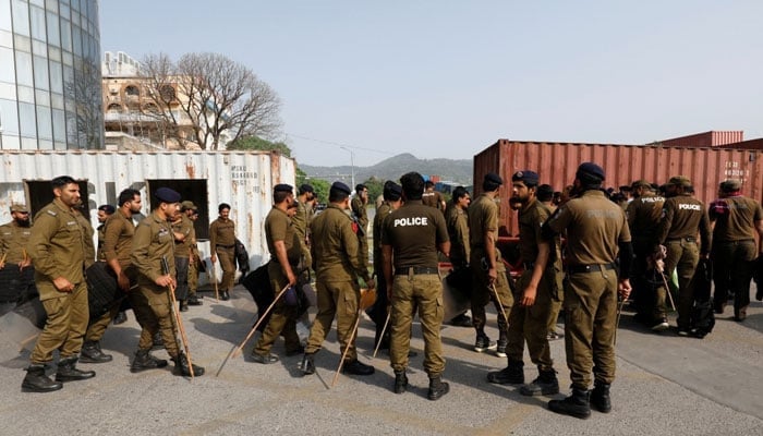 Police officers guard a street where shipping containers have been used to block the road leading towards the Red Zone and parliament building, in Islamabad, April 3, 2022. — Reuters