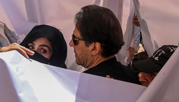 Imran Khan (R), along with his wife Bushra Bibi (L) appear before a court in this undated picture. — AFP/File
