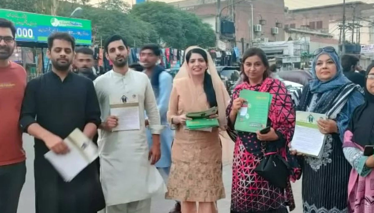 PTI leader Aliya Hamza is distributing a pamphlet in connection with the partys anti-govt campaign last year. — Instagram/aliya.hamza.malik