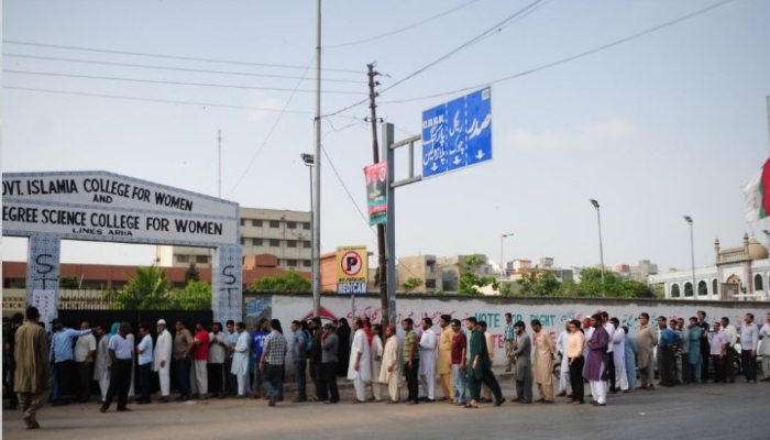 Pakistani voters queue for their turn to cast their ballots outside a polling station in Karachi on May 11, 2013. —AFP