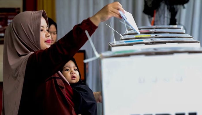 A woman votes at a polling station during the general election in Bogor, West Java, Indonesia, on February 14.  —Reuters