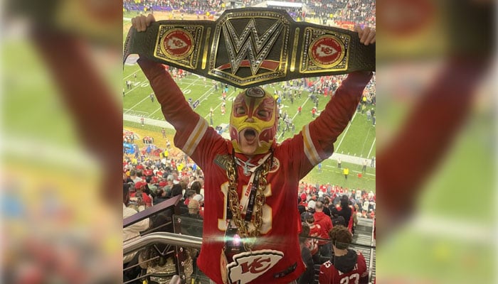 Elijah Smith poses in his Kansas City Chiefs outfit and merchandise with his lucky luchador mask. — CBS News via Sarah Smith