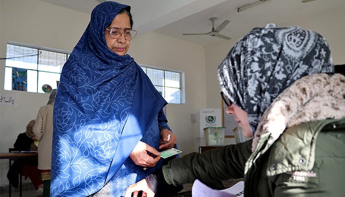 Shahida Praveen, 55, a voter, registers herself before casting her vote at a polling station during the general election in Rawalpindi, February 8, 2024. — Reuters