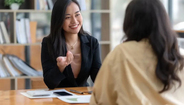 The representational image of two coworkers talking to each other. — Unsplash