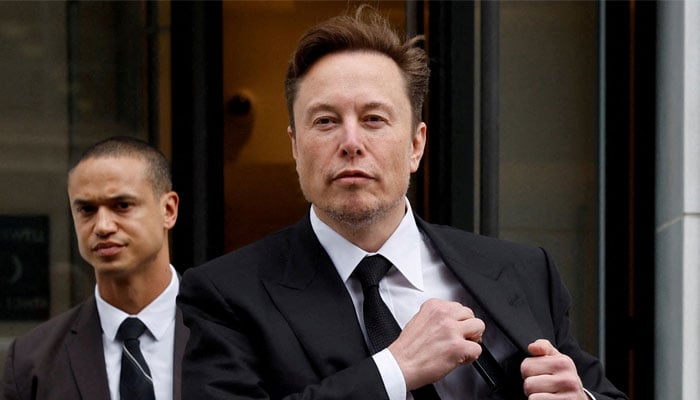 Tesla CEO Elon Musk and his security detail depart the companys local office in Washington, US on January 27, 2023. — Reuters