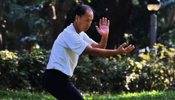 A man demonstrates tai chi exercise in a park. — Unsplash