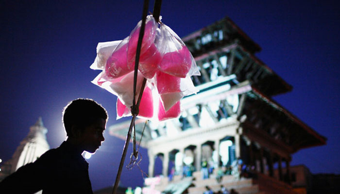 A boy selling cotton candy waits for customers on the streets. The boy, among other similar children, does not go to school and earns around $2 per day selling cotton candy. —Reuters