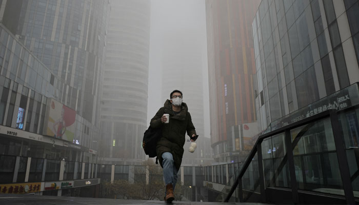 A man walks in the Sanlitun shopping district on a polluted day, in Beijing, China, November 6, 2021. —Reuters