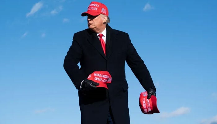 Donald Trump giving out Make America Great Again, (Maga) hats at a rally. — AFP/File
