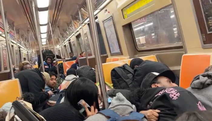 The picture shows people ducking inside the Brooklyn train where the fight erupted between two men. — New York Post via X/@JoyceMeetsWorld