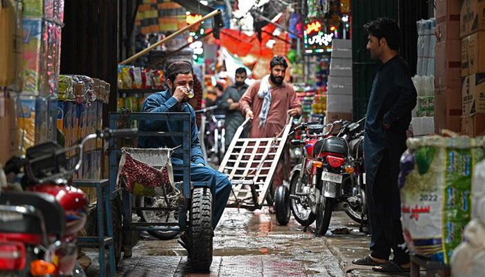 A trader drinks tea along an alley in a market in Rawalpindi on June 1, 2023. — AFP