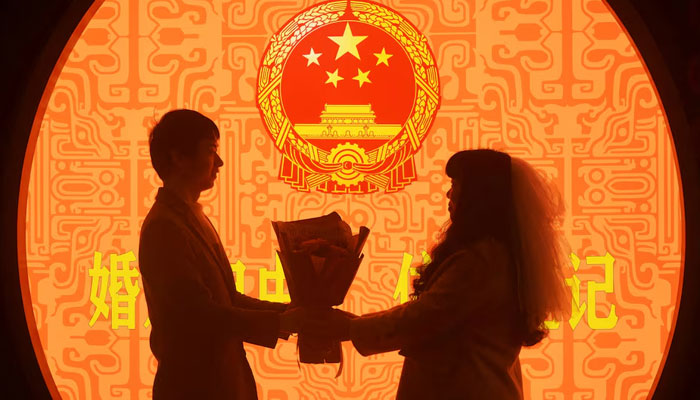 A newly wed couple pose for pictures on Valentines Day at a marriage registration office in Hangzhou, Zhejiang province, China February 14, 2023. — Reuters