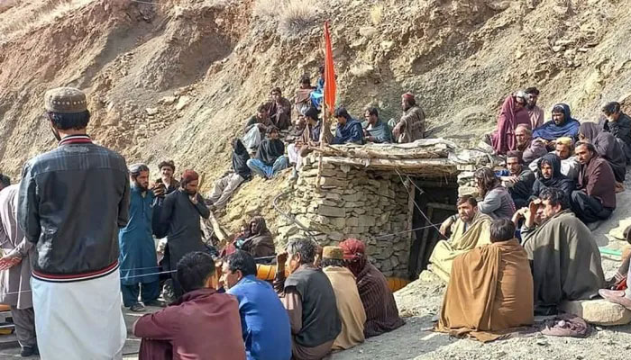 Miners sit outside a coalpit in the mining region in Balochistan on March 20, 2024. —  AFP