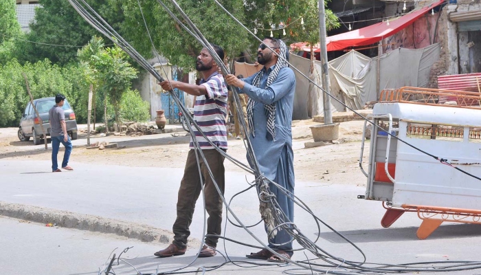 Linemen busy in cutting the illegal line of electricity during crackdown against illegal connections in Hyderabad on September 23, 2023. —APP