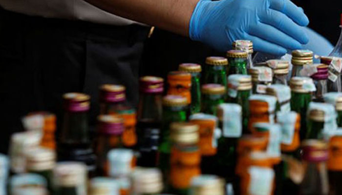 This representational image shows police officials displaying liquor bottles after a raid at a police station in Jakarta, Indonesia on April 11, 2018. — Reuters