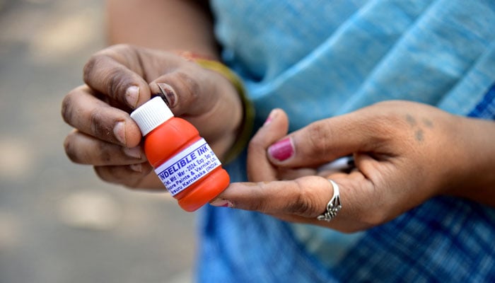 A staff shows an indelible ink vial that is used during elections to prevent duplication of voting, at the government-run Mysore Paints and Varnish company in Mysuru, India, March 12, 2024. —Reuters
