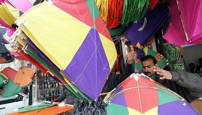 A kite-vendor awaits customers at his shop in Lahore. —Reuters/File