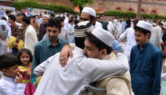 People exchange Eid greetings after offering Eidul Fitr prayers in Islamabad on July 29, 2014. — AFP