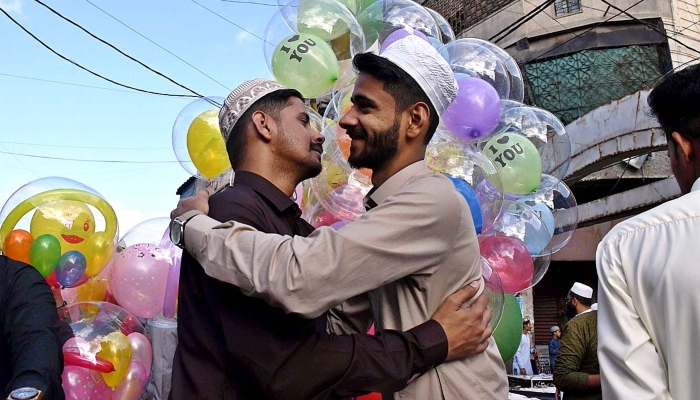کراچی میں 23 اپریل 2023 کو عید الفطر کی نماز ادا کرنے کے بعد مومنین ایک دوسرے سے عید کی مبارکباد کا تبادلہ کر رہے ہیں۔ -اے پی پی