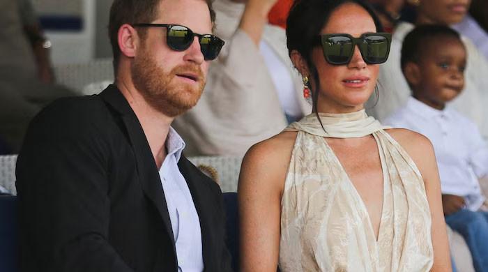 Meghan Markle striding away from Prince Harry and throwing signs