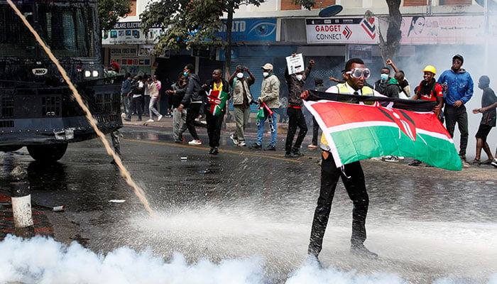 A demonstrator holds a Kenyan flag as police use water cannons and tear gas to disperse protesters during a demonstration against Kenyas proposed finance bill 2024/2025 in Nairobi, Kenya, June 25, 2024. — Reuters