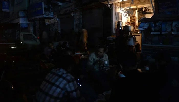 People sit outside at a cafe in Pakistan amid loadshedding. — AFP/File