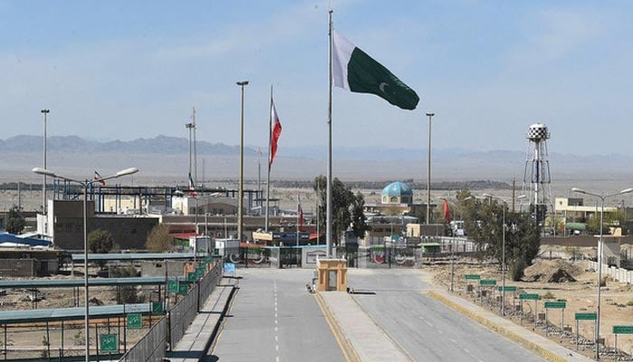 Pakistani and Iranian flags flutter on the border between the two countries in Taftan. — AFP/File