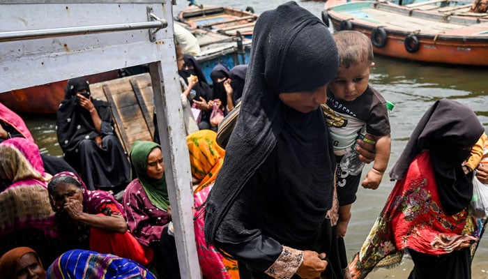 Women arrive on a boat ambulance for a medical examination appointment, at Baba Island along the Karachi Harbour, in Karachi. — AFP