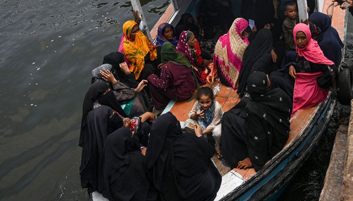 خواتین 6 جون 2024 کو کراچی میں کراچی ہاربر کے ساتھ واقع بابا جزیرے پر طبی معائنے کے لیے ایک کشتی ایمبولینس پر پہنچ رہی ہیں۔ — اے ایف پی