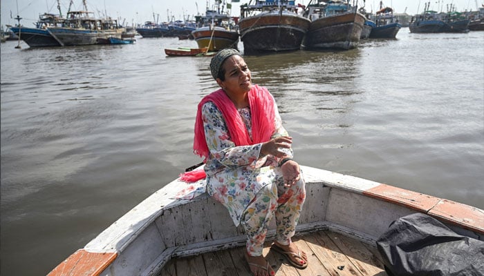 نیہا منکانی، ایک دائی، اے ایف پی کے ساتھ ایک انٹرویو کے دوران بات کر رہی ہیں جب وہ کراچی کی بندرگاہ کے ساتھ بابا آئی لینڈ کے ساحل کے قریب بیٹھی ہیں۔  - اے ایف پی