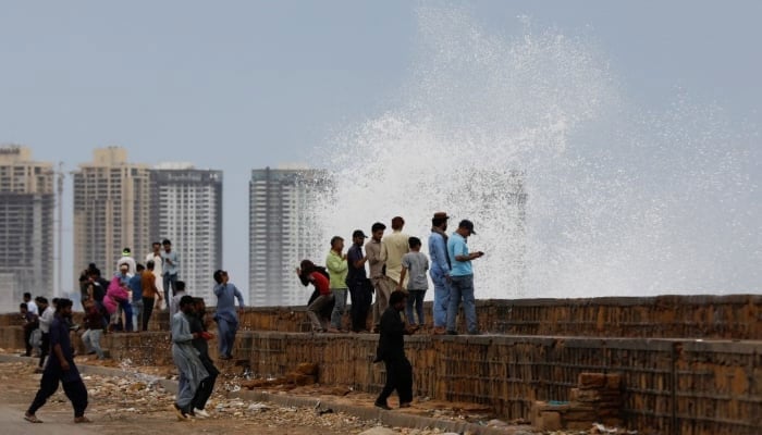 People gather near the rising waves, before the arrival of the cyclonic storm, Biparjoy, over the Arabian Sea, at Clifton Beach, in Karachi, Pakistan June 13, 2023. — Reuters