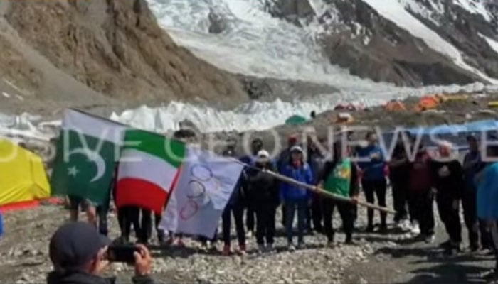 اٹلی-پاکستان K2 جوبلی مہم کی ٹیم کو K2 بیس کیمپ پر پاکستان، اٹلی اور اولمپکس کے جھنڈے لہراتے ہوئے دیکھا جا سکتا ہے جسے اب بھی ایک ویڈیو سے لیا گیا ہے۔  - اسکرین گریب/یوٹیوب/جیو نیوز لائیو