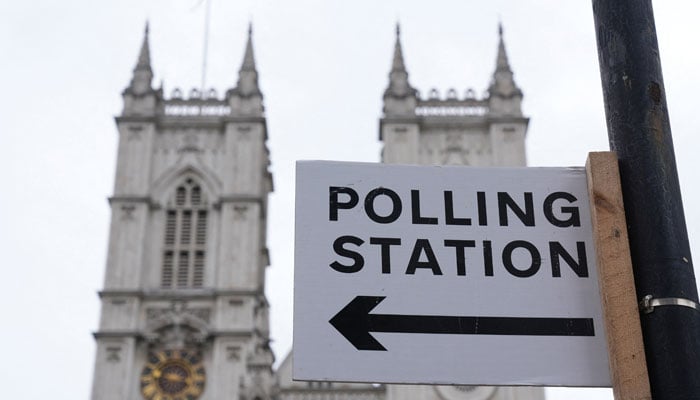 A polling station direction sign is attached to a street sign near to Westminster Abbey, ahead of general elections, in London, Britain July 3, 2024. — Reuters