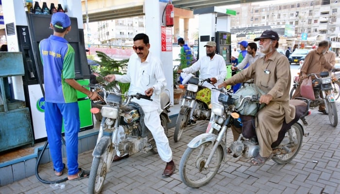 Motorcyclists waiting for their turn to fill fuel in their bikes at a petrol pump on May 16, 2024. —APP