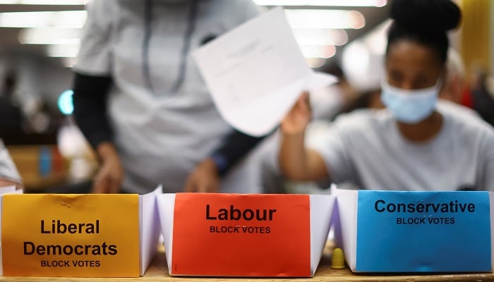 UK polling staff busy arranging ballot papers at a polling station. — Reuters