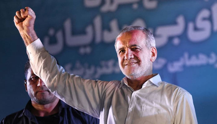 Iranian President Masoud Pezeshkian raises his fist as he arrives for his campaign rally, two days before a presidential election runoff following a first round marked by a historically low turnout, at a stadium in Tehran on July 3, 2024. — AFP